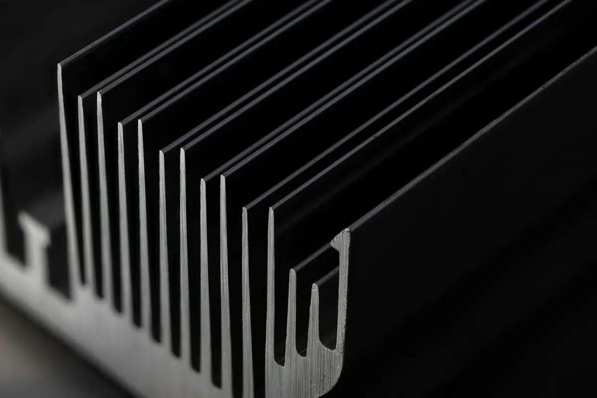 Perfil de aluminio extruido en primer plano, sobre fondo oscuro